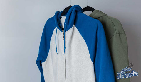 Two hoodies hanging on a clothing rack