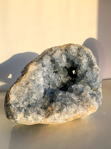 A pale blue Celestite geode sparkles in the late afternoon sun 