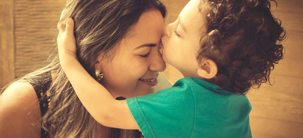 Niño besando a su madre en la frente.