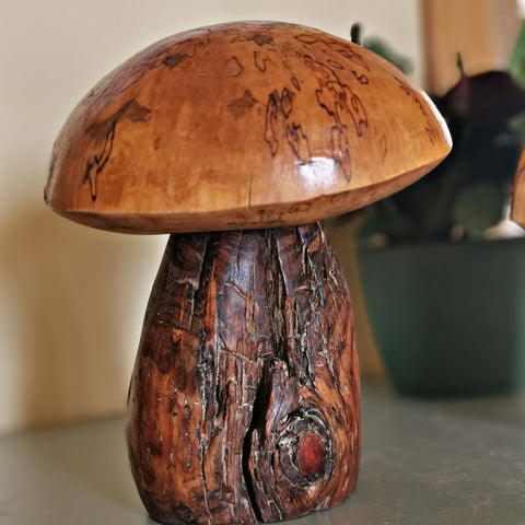 wood mushroom sculpture with a yellow cap and dark brown body 