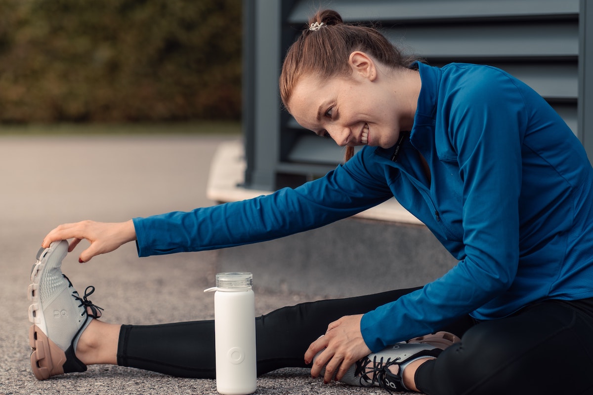 Woman sitting on ground stretching