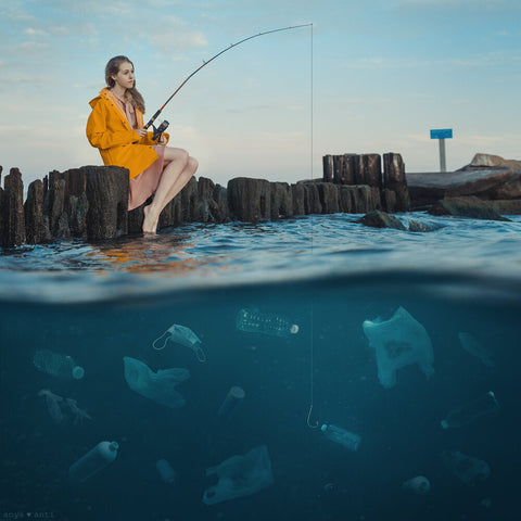 an Anya Anti photograph of a young woman fishing with refuse in the water