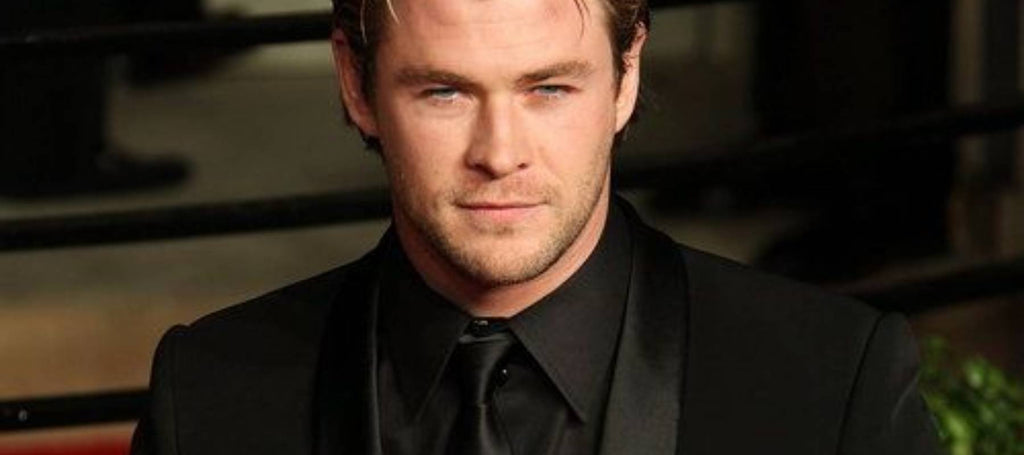 Chris Hemsworth con traje negro, camisa negra y corbata negra