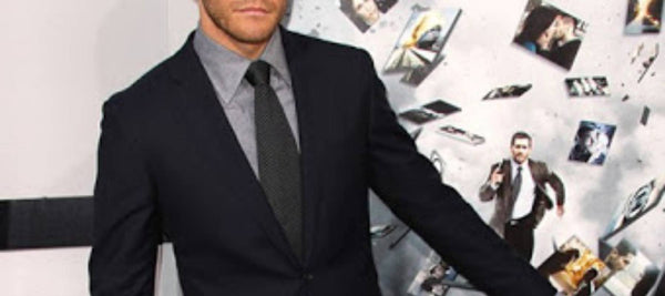 Mann mit schwarzer Krawatte, grauem Hemd und schwarzem Anzug