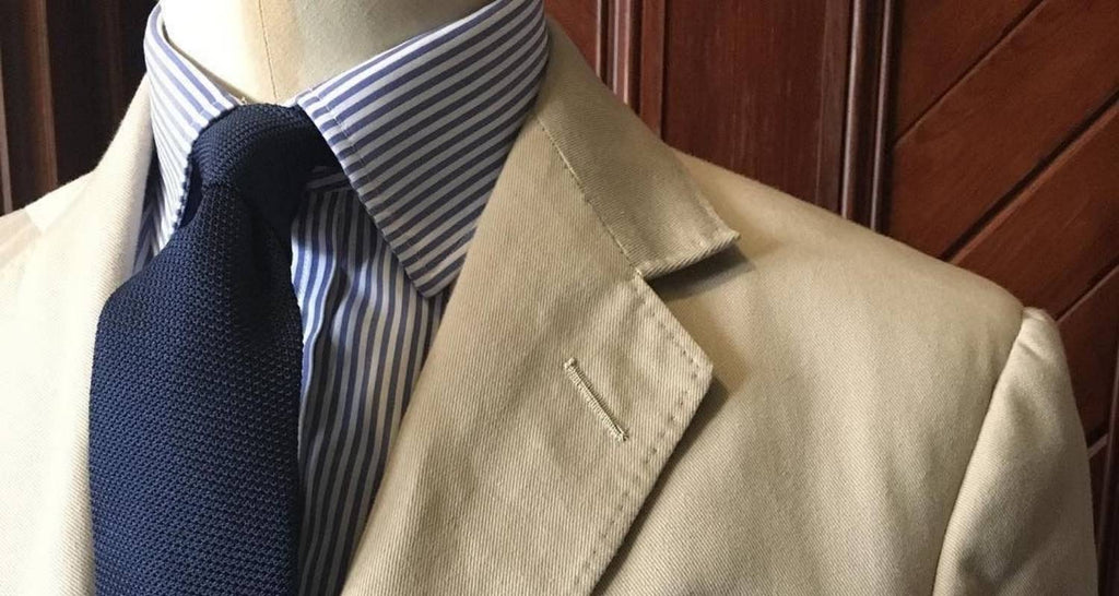 Beigefarbener Anzug und weißes Hemd und marineblaue Krawatte 