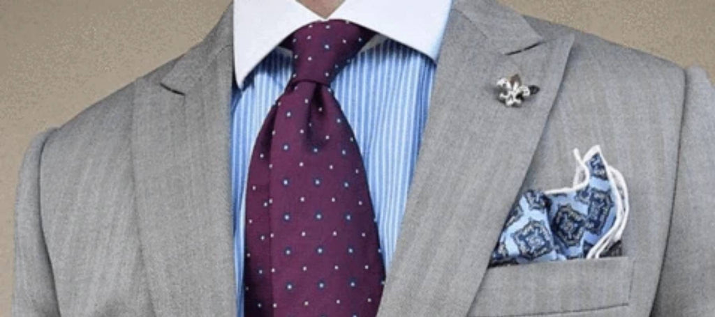 Grauer Anzug, rote Krawatte, blaues Hemd und blaues Taschentuch