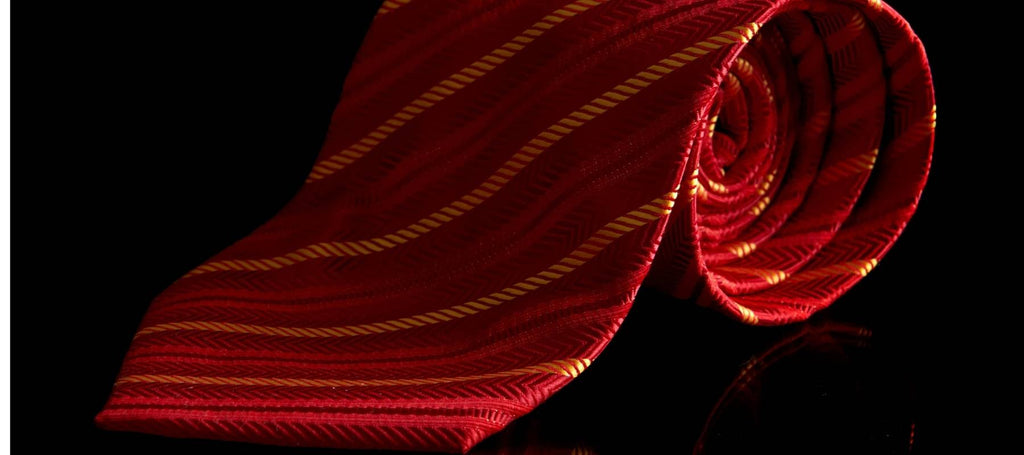 Corbata de rayas rojas y amarillas sobre fondo negro