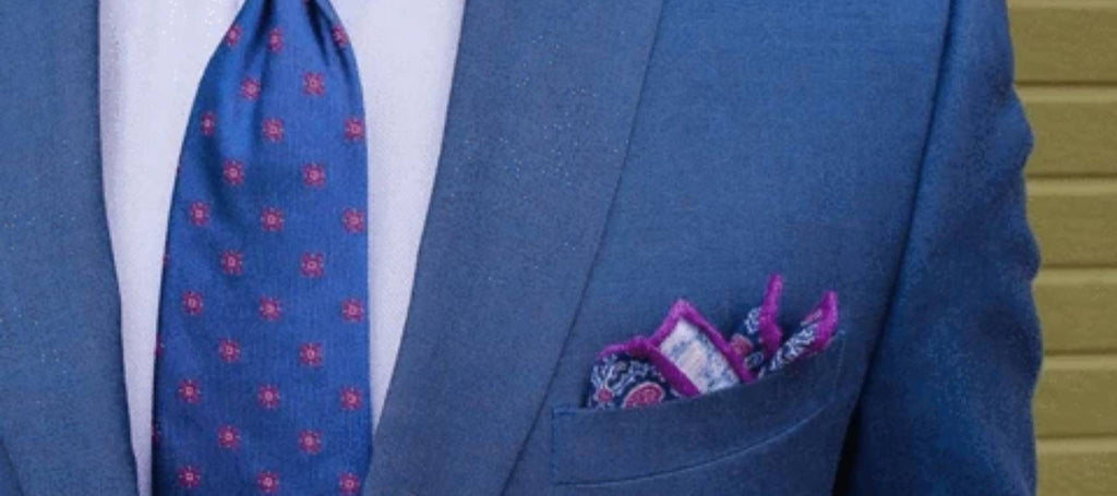 Corbata y bolso de mano estampados con traje azul marino