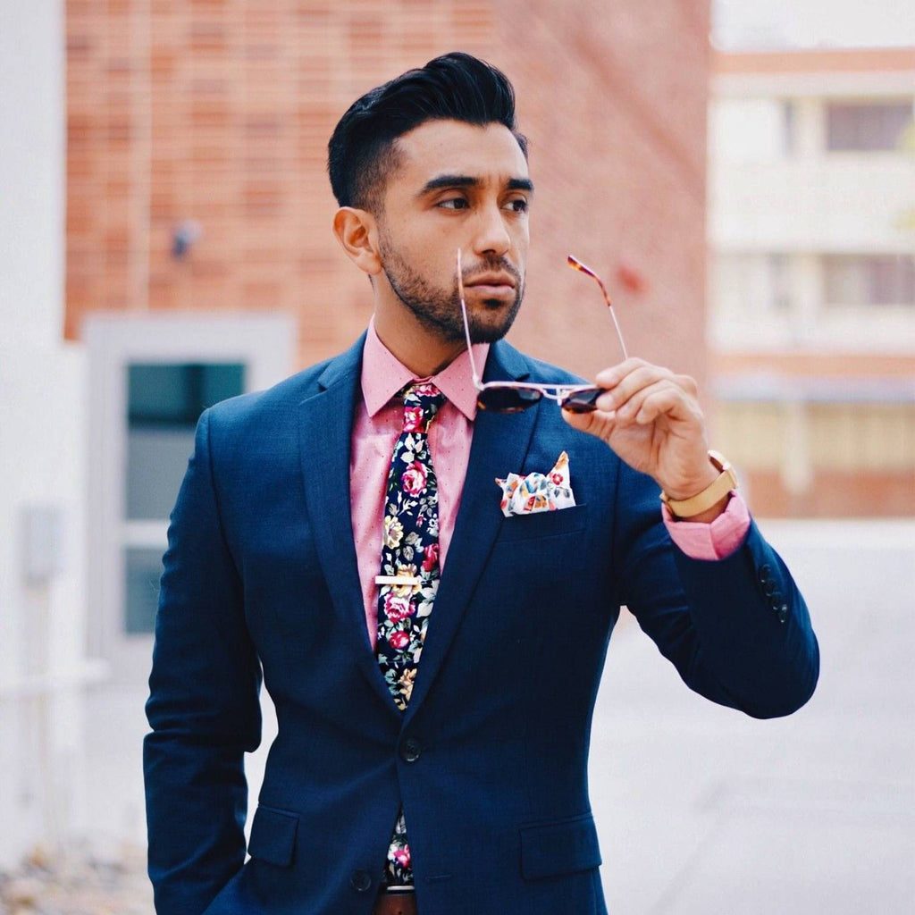 Hombre con traje azul, camisa blanca y corbata rosa