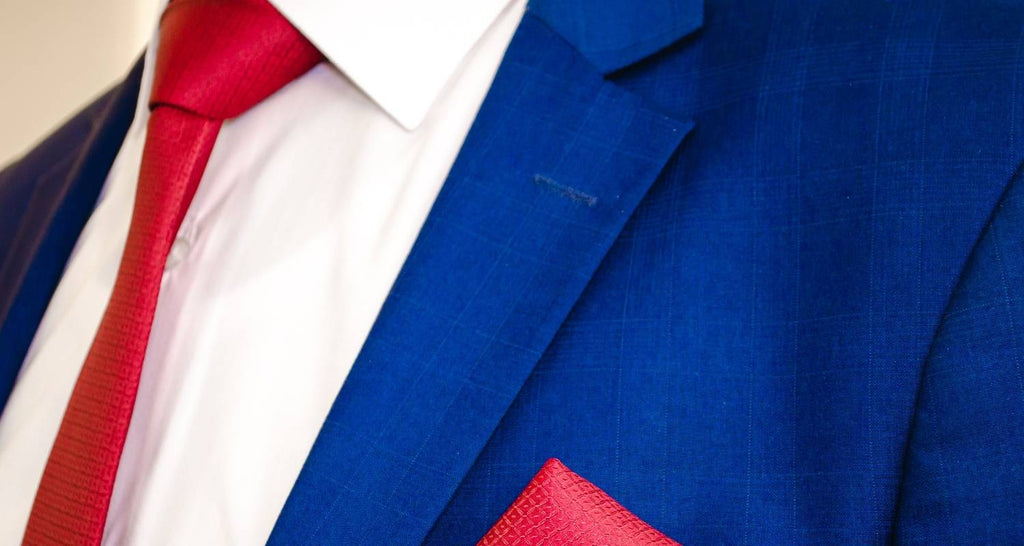 Hombre con traje azul, camisa blanca y corbata roja