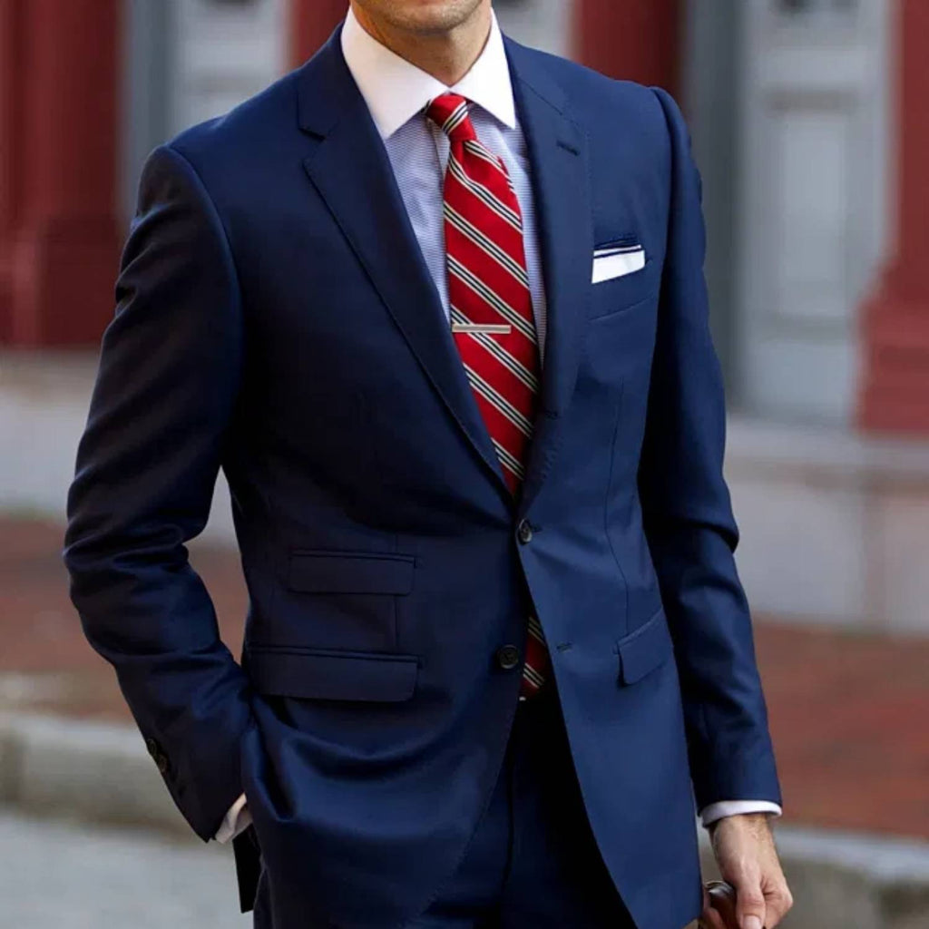 Hombre con traje azul, camisa azul y corbata roja