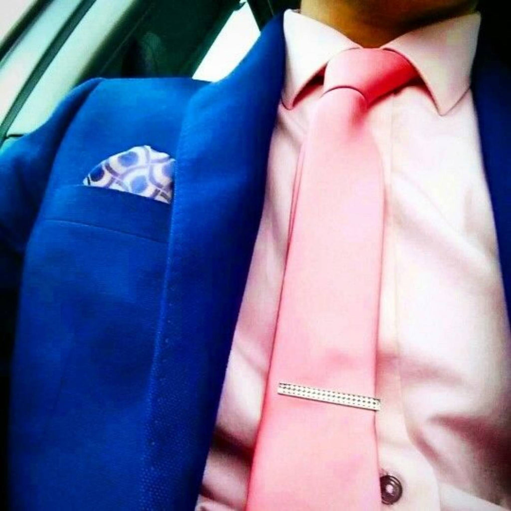 Hombre con traje azul, camisa rosa y corbata