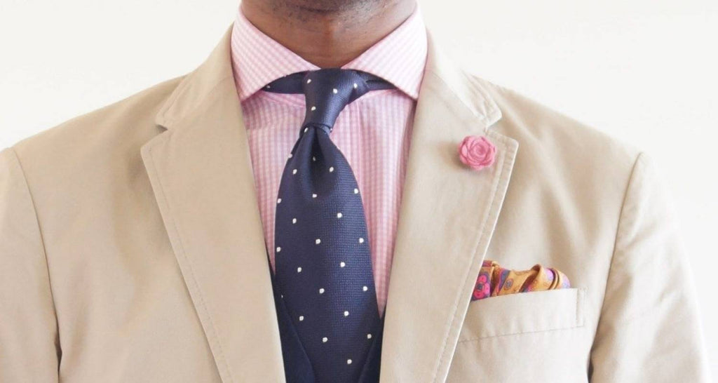 Mann Beigefarbener Anzug, rosa Hemd und marineblaue Krawatte