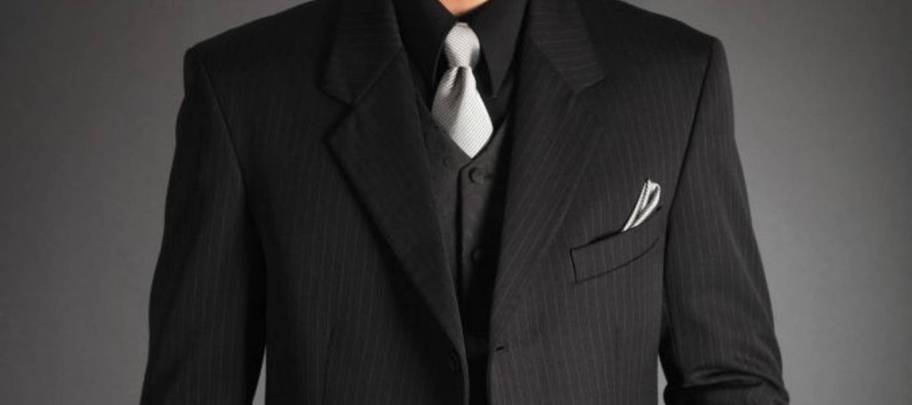 Hombre con traje negro, camisa negra y corbata plateada