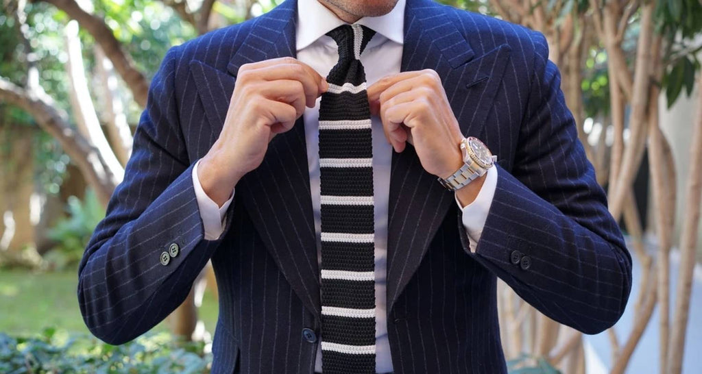 Die gestrickten Krawatten mit Streifen schwarz Mann blauen Anzug und weißes Hemd