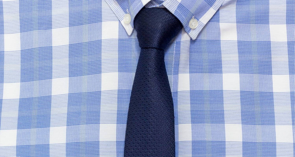 Corbatas lisas de punto azul sobre una camisa a cuadros