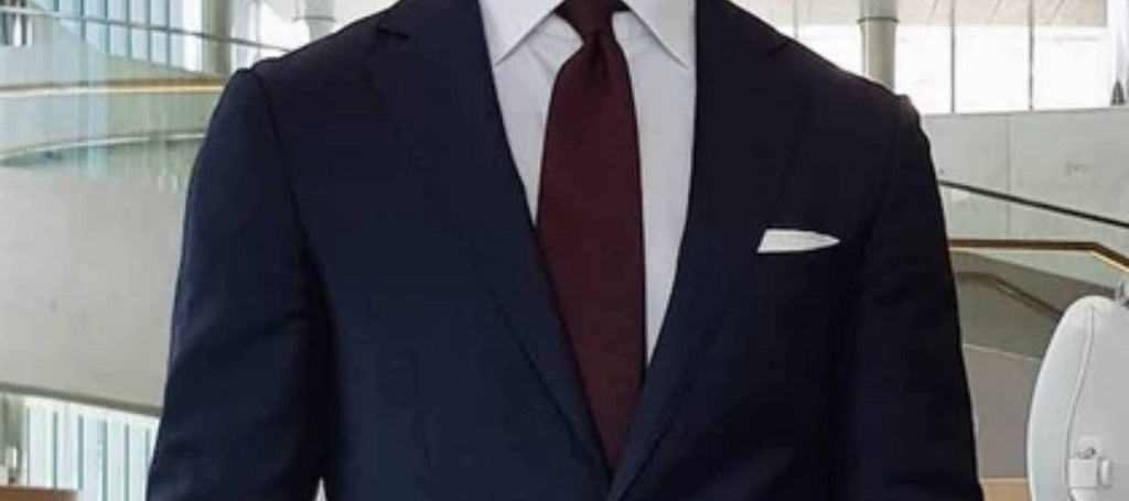 Clutch blanco liso, corbata roja y traje azul marino