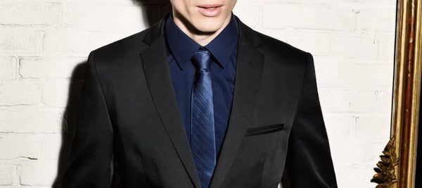 Ein Mann mit einer blauen Krawatte, einem blauen Hemd und einem schwarzen Anzug