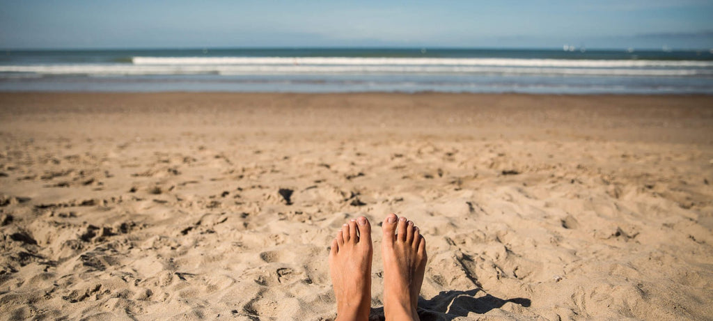 Photo de pieds sur la plage, la mer au loin