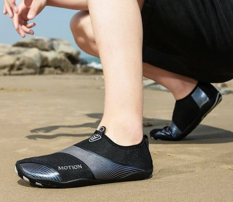 Homme avec chaussures de plage Motion Argent d'Aquashoes marchant sur le sable