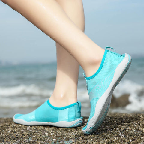 Femme avec chaussures de plage Motion Bleu d'Aquashoes marchant sur le sable
