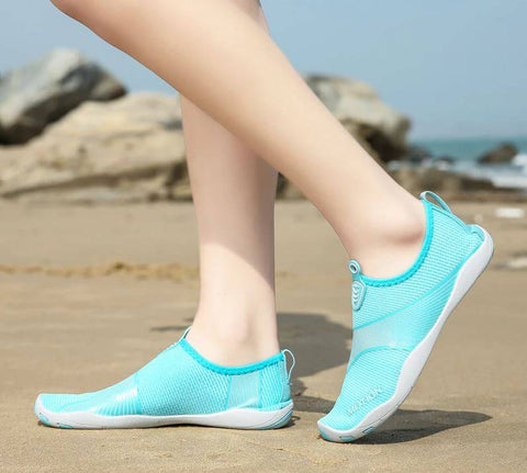 Femme avec chaussures de plage Motion Bleu d'Aquashoes marchant sur le sable