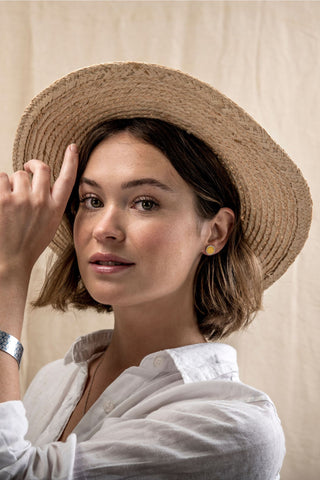 Model wearing yellow earings and ethical bracelet