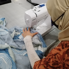 Seamstress sewing Batik Boutique's products