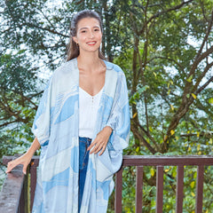 Lifestyle shot of woman in blue Sky Bukit batik kimono from Batik Boutique's Raya 2023 collection inspired by Malaysia's hills.