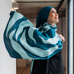 a female model posing in a lifestyle photo while wearing authentic malaysian batik in the pattern teal rose