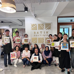 a group photo holding up their batik diy kit for team building activity