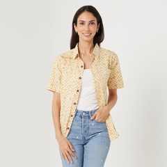 a woman posing in front of a white background in a batik shirt for batik boutique