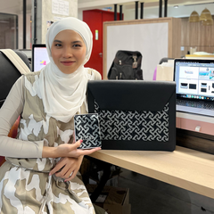 a designer from batik boutique holding the bag that she designed for the prime minister of malaysia