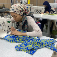 a seamstress in the process of making batik shirts