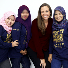 a photo of amy blair, the ceo and owner of batik boutique, posing with the seamstresses