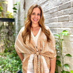 amy blair, ceo and founder of batik boutique posing in front of a greeneries while wearing a batik boutique kimono