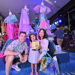 a family standing in front of their child's creation for the premier of disney's little mermaid, made by batik boutique