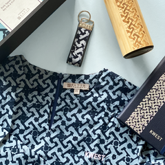 Batik Boutique's collaboration with KWEST showcased in this image, featuring custom gift sets with KWEST logo on Baju Kedah top, Batik Journal, Wooden Tumbler & Batik Key Fob.