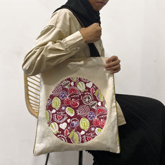 a model showcasing a batik inspired tote bag in the pattern maroon durian