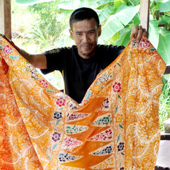 an artisan proudly shows his authentic batik that he worked on