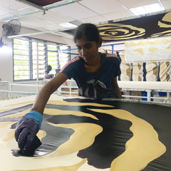 a moder female artisan in the process of coloring in authentic malaysian batik