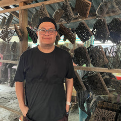 a picture of a batik artisan standing in front of batik blocks