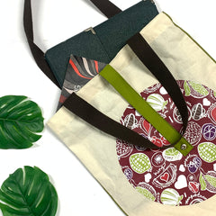 a lifestyle photo of the tote bag in the pattern maroon durian against a neutral background