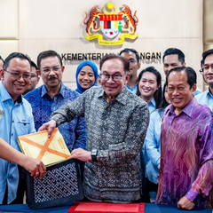 prime minister of malaysia inserting an important document within the bag made of batik mdae by batik boutique