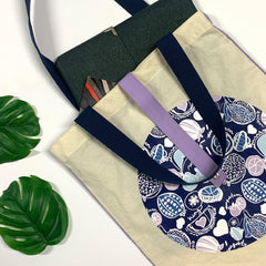 a lifestyle photo of a tote bag in the pattern navy durian against a neutral background