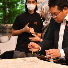 a corporate businessman painting batik as a unique and fun activity at the company