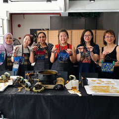 a group of corporate workers posing in front of their own batik designs that they diy'd