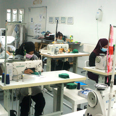 a picture of seamstresses in the middle of sewing batik