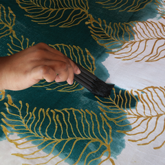 artisan in the process of painting batik