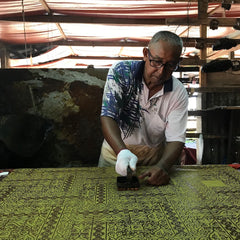 batik boutique artist using batik block on fabric